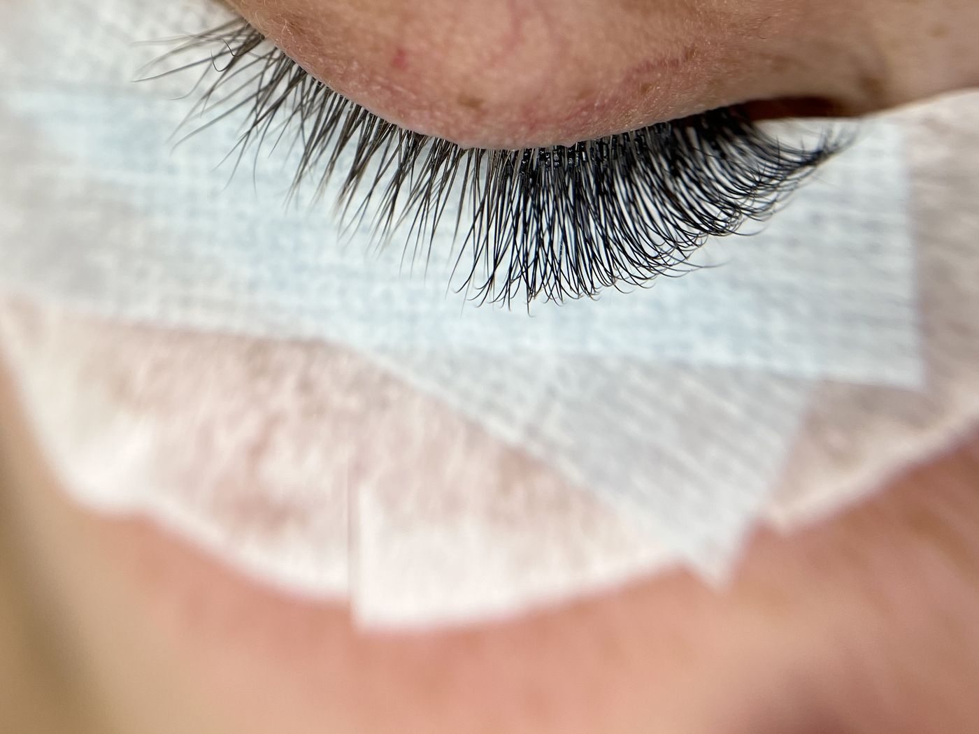 A lash extension set halfway through the appointment, one side done and one side natural